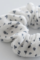 Close-up of indigo whisper scrunchie in white ribbed fabric with navy floral design – Avauma
